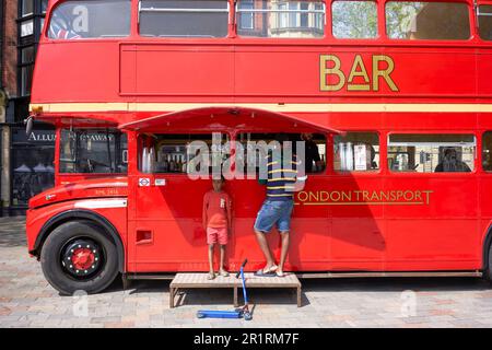 Uomo che acquista bevande in un bar mobile in un autobus convertito 1966 Routemaster London Foto Stock