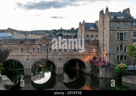Bath, Somerset, Inghilterra-Agosto 2022; Vista dello storico Pulteney Bridge nel tardo pomeriggio sole con notevole architettura e file di negozi Foto Stock