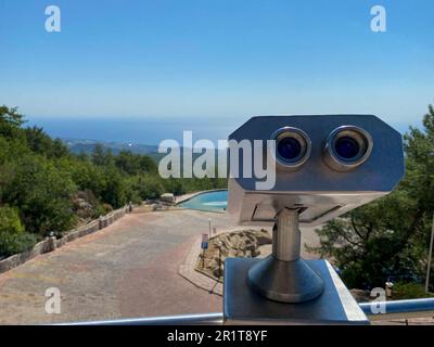 Telescopio turistico guardare la città con vista di Barcellona Spagna, primo piano vecchio binocolo in metallo sullo sfondo punto panoramico che si affaccia sulla montagna, alla moda Foto Stock