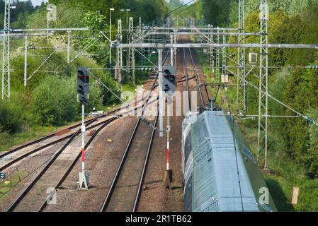 Treno Deutsche Bahn dopo la partenza da Papenburg in direzione Leer. I segnali sono rossi. Foto Stock