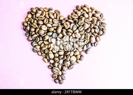 Bella texture a forma di cuore, da una selezione di caffè appena arrostiti, freschi e saturi, di qualità arabica naturale fragrante e robusta in grani. C Foto Stock