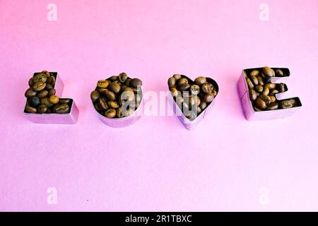 Bella texture con la parola "amore per San Valentino" scritta a base di chicchi di caffè arabica naturali, tostati e selezionati, robusta C Foto Stock