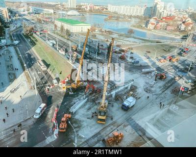 costruzione di un nuovo ponte nel centro della città. cavalcavia di cemento. costruzione con gru e attrezzature da costruzione. vista dalla parte superiore del sito Foto Stock