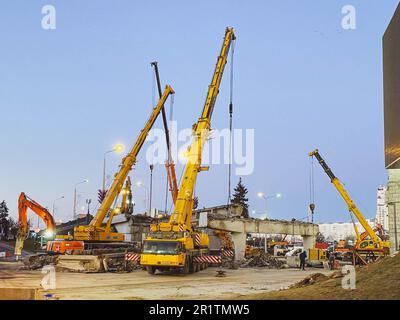 costruzione di un ponte rotto su una strada trafficata. le attrezzature da costruzione sul tratto stradale erettono un sorpasso, stende una strada asfaltata. Foto Stock