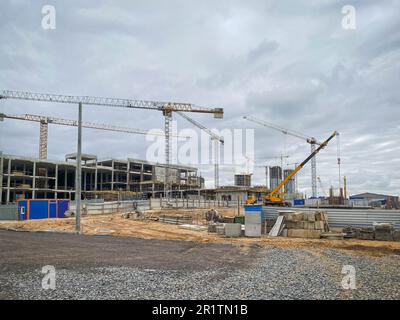 cantiere con gru per la costruzione di alti edifici a più piani. costruzione di un centro commerciale da blocchi di cemento in città Foto Stock