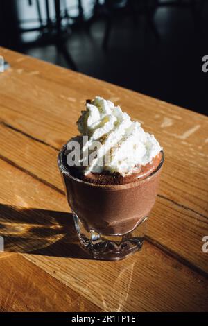 cioccolata calda in un bicchiere da caffè con panna montata Foto Stock