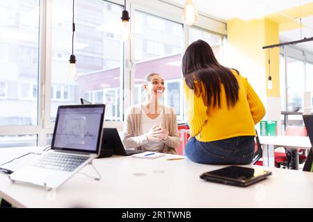 Amici femminili in un ufficio. I colleghi di lavoro che si batte sul lavoro. Foto Stock