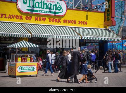 La famiglia ebraica hassidica cammina sul lungomare di fronte al ristorante Nathan's sull'isola di Coney Foto Stock