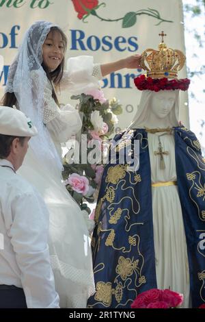 Una ragazza ispanica di 8 anni di Corona sorride dopo aver eseguito la cerimonia cattolica romana di maggio coronamento. Nel parco Flushing Meadows di Queens, New York. Foto Stock