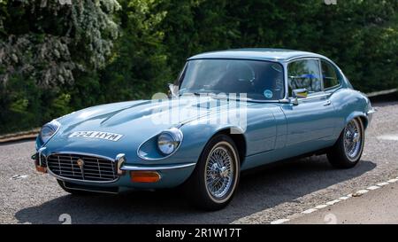 Stoke Goldington, Northants, Regno Unito - Maggio 14th 2023. 1972 blu JAGUAR 2+2 'e' TYPE AUTO classica auto sportiva che guida attraverso un villaggio inglese Foto Stock