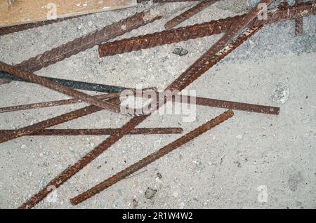 La costruzione arrugginita di ferro tessere su terreno di cemento al primo piano del cantiere particolare dall'alto Foto Stock