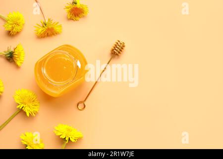 Vaso con miele di dente di leone su fondo arancione Foto Stock