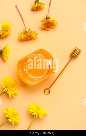 Vaso con miele di dente di leone su fondo arancione Foto Stock