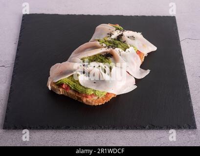 pane con avocado, pomodoro schiacciato e carne fredda di tacchino Foto Stock