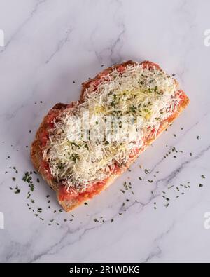delizioso pane tostato con pomodoro, formaggio grattugiato e tonno Foto Stock