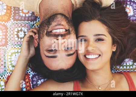 L'amore è la nostra sensazione preferita. Ritratto ad angolo alto di una giovane coppia felice che si rilassa su una coperta all'esterno. Foto Stock