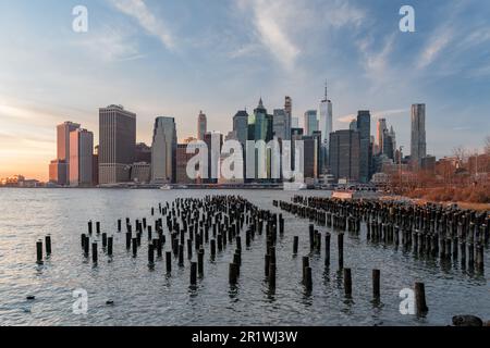 Skyline di Lower Manhattan durante un tramonto invernale, visto dal Brooklyn Bridge Park, New York Foto Stock
