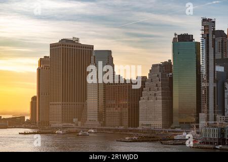 Grattacieli a Lower Manhattan che si affacciano sull'East River durante un tramonto invernale, New York Foto Stock