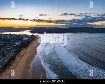 Alba con nuvole sparse e piccole onde a Ocean Beach a Umina Beach sulla costa centrale, NSW, Australia. Foto Stock