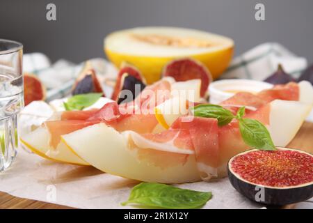 Gustosi meloni, jamon e fichi serviti su tavola di legno Foto Stock