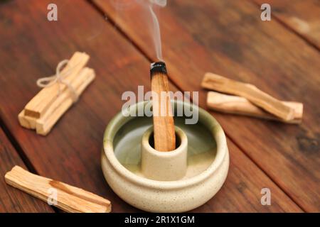 Bastone di palo Santo che frolla in supporto su tavolo di legno Foto Stock