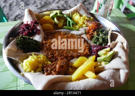 Injera Bayonet - cibo tradizionale etiope - verdure e lenticchie servite su pane fermentato spugnoso Foto Stock