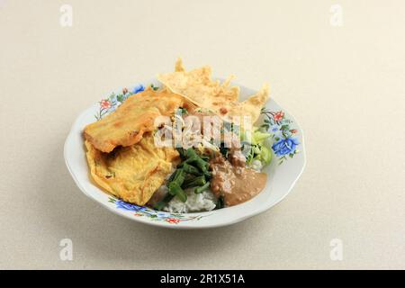 Pecel Sego, riso con salsa di arachidi piccante e verdure al vapore. Menu piatto tradizionale indonesiano giavanese per colazione, pranzo o cena. Popul Foto Stock