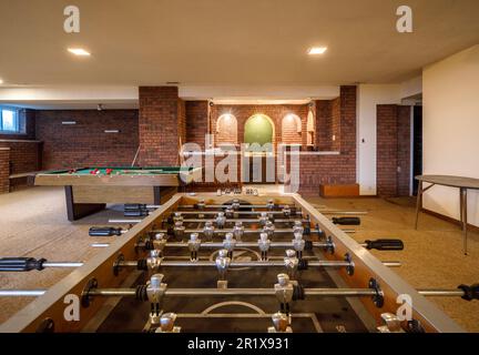 Una sala ricreativa con un tavolo da calcio, tavolo da biliardo e un bar nel seminterrato di una grande casa. Questa casa è stata da allora demolita. Foto Stock