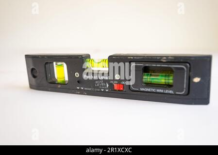 Livella a bolla d'aria Piccolo, piccolo, tascabile. Isolato su sfondo bianco. Utilizzato nei lavori di costruzione. Foto Stock