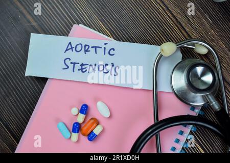 Concetto di stenosi aortica scrivere su note adesive con stetoscopio isolato su tavola di legno. Foto Stock