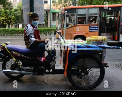 Un uomo thailandese che vende cornocchie e noci di terra al vapore dal suo carrello alimentare moto su Sukhumvit Road a Bangkok, Thailandia. Foto Stock