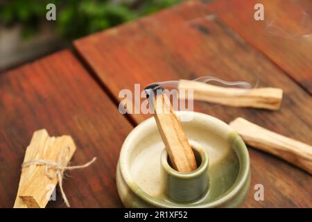Bastone di palo Santo che frolla in supporto su tavolo di legno Foto Stock