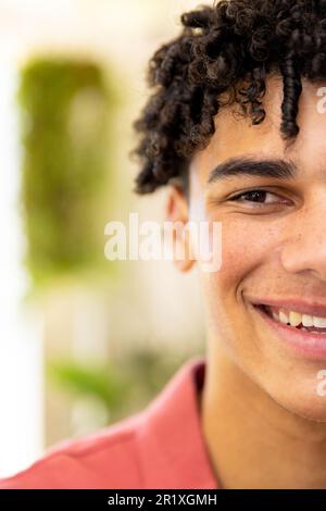 Mezzo ritratto di felice uomo biraciale con capelli ricci neri sorridenti a casa, con spazio copia Foto Stock