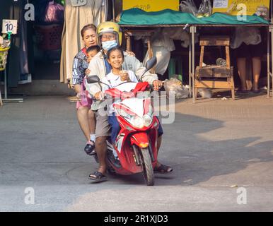 SAMUT PRAKAN, THAILANDIA, MAR 03 2023, una coppia anziana sta guidando una moto con bambini piccoli Foto Stock