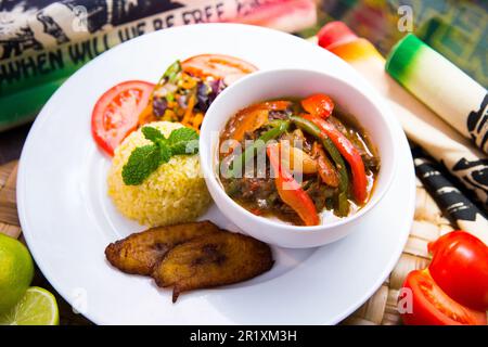 Piatto di verdure giamaicano servito con riso e banana. Foto Stock