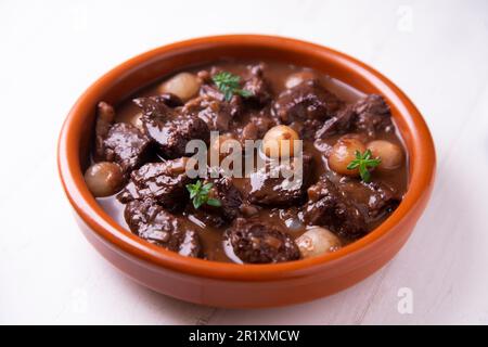 Manzo brasato con cipolle cotte al vino rosso. Tradizionale tapa spagnola. Foto Stock