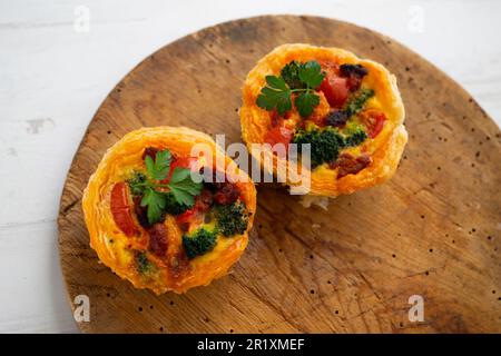 Crostate di pasta sfoglia farcite con broccoli, uova e pomodori ciliegini. Foto Stock