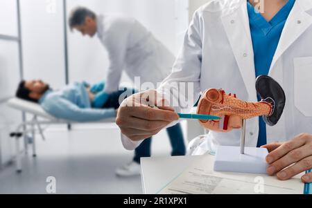 il medico palpa l'uomo paziente addome e esamina la pancia in clinica medica per analizzare lo stato del pancreas. Trattamento di malattie pancreatiche, acute e. Foto Stock