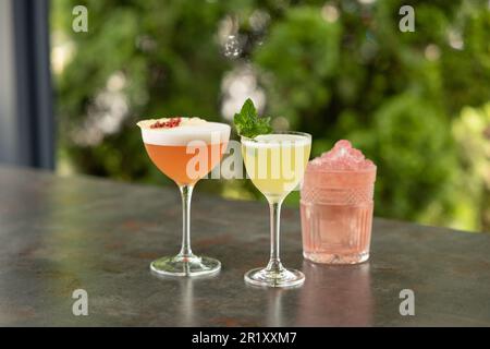 Diversi deliziosi cocktail estivi sul tavolo grigio nel ristorante all'aperto Foto Stock