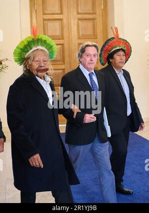 Berlino, Germania. 16th maggio, 2023. Jean-Pierre Dutilleux (centro), attivista, autore e co-fondatore dell'organizzazione della foresta pluviale AFV, guida il leader tribale Raoni Metuktrire (l), rappresentante delle preoccupazioni delle popolazioni indigene dell'Amazzonia e della protezione della foresta pluviale, al Palazzo Bellevue. Il Presidente Federale invita il Capo Metuktire a parlare. Credit: Annette Riedl/dpa/Alamy Live News Foto Stock