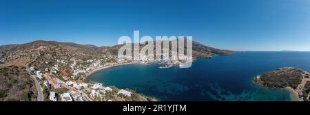 Andros isola, del villaggio di Batsi, Cicladi destinazione Grecia. Vista panoramica aerea del paesaggio, del porto, dell'edificio, del mare limpido, del cielo blu. Banner Foto Stock