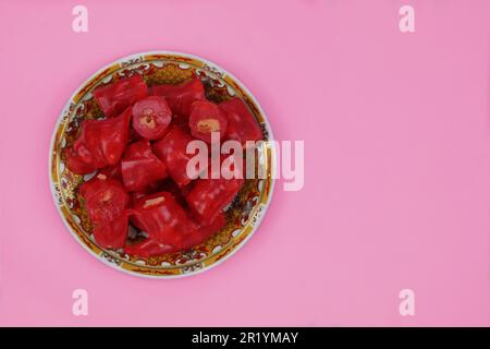 Dessert tatar Crimea. Churchkhela fresca con noci in un piatto su sfondo rosa. Dolce fatto in casa. Foto Stock