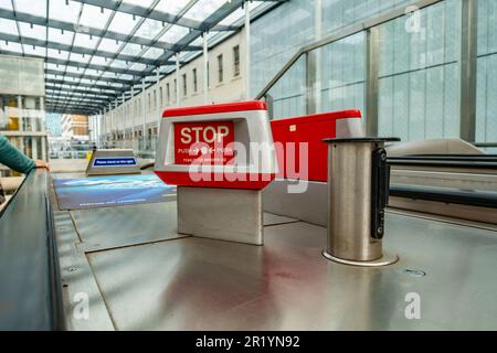 Un pulsante di arresto di emergenza per arrestare una scala mobile che conduce alla metropolitana di Londra alla stazione ferroviaria di Paddington. Foto Stock