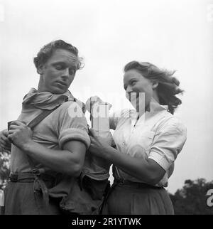 Coppia in un pic-nic. Una giovane coppia ha portato con sé panini e bevande analcoliche in questo giorno d'estate. La toglie dallo zaino dell'uomo. Svezia 1944. Kristoffersson Rif. M20-2 Foto Stock