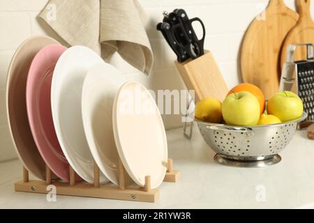 Piatti, diversi utensili da cucina e frutta sul banco della cucina Foto Stock