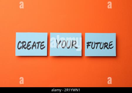 Frase motivazionale Crea il tuo futuro fatto di note appiccicose con parole su sfondo arancione Foto Stock