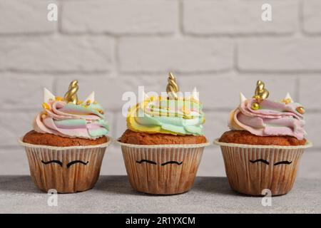 Tortine dolci e carine di unicorno su un tavolo grigio chiaro Foto Stock