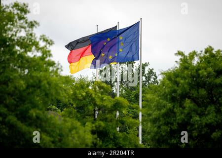 Berlino, Germania. 16th maggio, 2023. Le bandiere dell'Europa e della Germania stanno sventolando nel vento dietro gli alberi. Berlino, 16 maggio 2023. Credit: dpa/Alamy Live News Foto Stock