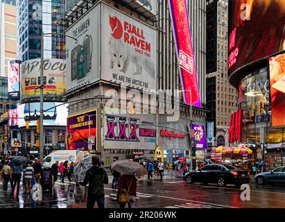Gli ombrelli sono fuori sotto una leggera pioggia di settembre a Times Square, crocevia del mondo. Foto Stock