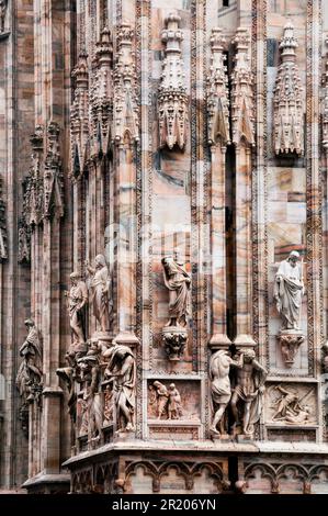 Bassorilievo statue di santi e martiri e pannelli di marmo con storie bibliche, Duomo di Milano, Italia. Foto Stock